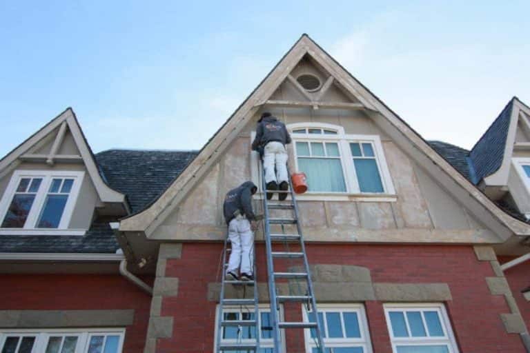 Earl's Paintworks Calgary - Staff working on ladders outside home